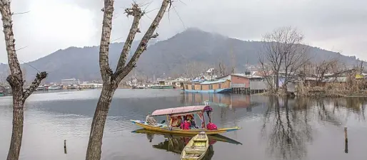  ??  ?? ↑
Tourists ride a Shikara on Dal Lake in Srinagar, recently.
Associated Press