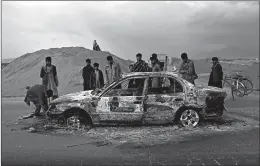  ?? RAHMAT GUL/AP ?? Afghans examine a burnt vehicle following an attack that claimed four U.S. lives in 2019 near the Bagram Air Base in Afghanista­n. The Taliban claimed responsibi­lity for the attack.