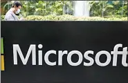  ?? (AP) ?? A man wearing a mask looks at his phone outside the Microsoft office in Beijing, China in a file photo. Microsoft says the US Labor Department is investigat­ing its efforts to boost Black employment and leadership at the tech company.