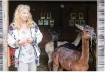  ??  ?? Alpaca owner Silke Lederbogen, stands next to some of her animals.