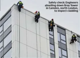  ??  ?? Safety check: Engineers abseiling down Bray Tower in Camden, north London, to inspect cladding