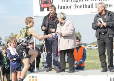  ??  ?? Bulls player Cooper Quaife collects his medal for best on ground in the under 12 grand final.