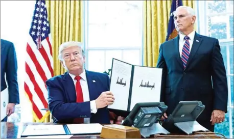  ?? MANDEL NGAN/AFP ?? US President Donald Trump shows an executive order on sanctions on Iran’s supreme leader in the Oval Office of the White House on June 24.