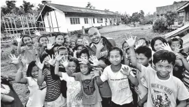  ?? A.DAYAO, M. LASACA/IDS COMVAL ?? MEET THE STUDENTS. Smiling pupils, from a far-flung barangay in Manurigao, New Bataan, pose with Compostela Valley SP member Tyron Uy. The children seldom see visitors due to the remoteness of the place.