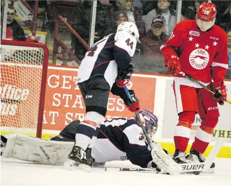  ?? BRIAN KELLY ?? The Spitfires Nathan Staios watches as goalie Colton Incze grabs the puck away from the Sault Ste. Marie Greyhounds’ Joe Carroll during the first-period at GFL Memorial Gardens in Sault Ste. Marie on Friday.