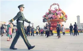  ?? — Reuters ?? A paramilita­ry police officer patrols the area around Tiananmen Square ahead of the 19th National Congress of the Communist Party of China, in Beijing, on Friday.