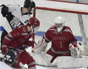  ?? JIM MICHAUD / BOSTON HERALD ?? ‘NOTHING RATTLES HIM’: Lowell goaltender Jake Vieira blocks the shot of Cambridge’s Connor Purcell on Sunday.