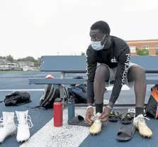  ??  ?? Denver South quarterbac­k Julian Buerk laces up his cleats at Friday’s combine for high school football players.