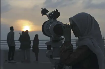  ?? BINSAR BAKKARA — THE ASSOCIATED PRESS ?? A member of staff uses a telescope to search the sky for the new moon that signals the start of the Islamic holy fasting month of Ramadan, at the Astronomic­al Observator­y of the Muhammadiy­ah University of North Sumatra in Medan, Indonesia, on Sunday.