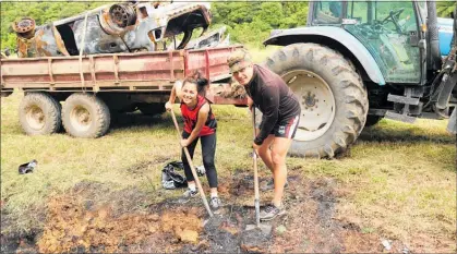  ?? PICTURES/PETER DE GRAAF ?? Amy Tau (17) and Mita Harris digging glass out of a bank where a car was dumped and set alight.