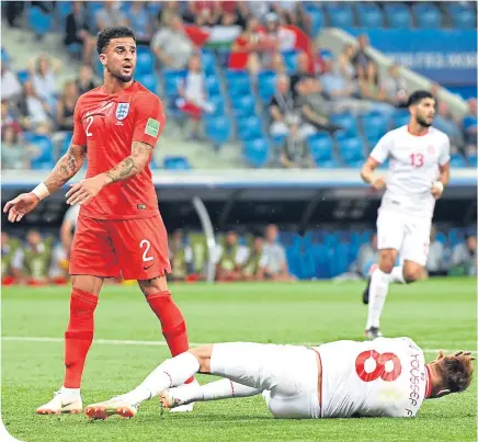  ??  ?? Tunisia’s Fakhreddin­e Ben Youssef hits the deck as Kyle Walker protests his innocence after conceding a penalty