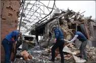  ?? (AP/DHA) ?? People remove debris from destroyed buildings Sunday in a residentia­l area in Ganja, Azerbaijan, after shelling by Armenian forces.