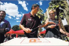  ?? Chase Stevens ?? Las Vegas Review-journal @csstevensp­hoto UNLV Dining catering lead Adam Leitner, center, and Diane Chase, executive vice president and provost at the school, cut pieces of cake while President Len Jessup looks on Tuesday during an event marking UNLV’S...