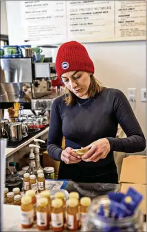  ?? KIM RAFF/NEW YORK TIMES ?? Anna Barrett labels juices at High Vibes Juicery and Wellness Bar in Park City, Utah, this month. “It’s been a bumpy ride, for sure,” said owner Jennifer Sutton. She is most worried about inflation, she said, as well as the prospect of a recession.