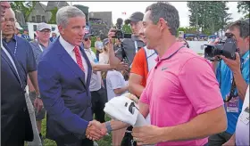  ?? Associated Press ?? Greetings: Rory McIlroy, front right, shakes hands with PGA Commission­er Jay Monahan after winning the Canadian Open golf tournament earlier this month in Toronto.