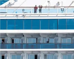  ?? JIJI PRESS/AFP VIA GETTY IMAGES ?? Passengers spend time on their balconies onboard the Diamond Princess cruise ship, with more than 3,700 people quarantine­d due to fears of the new coronaviru­s.