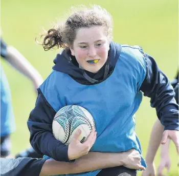  ?? PHOTOS: GREGOR RICHARDSON ?? Future Ferns? . . . Black Ferns halfback Kendra Cocksedge (top right) directs traffic while (clockwise from bottom right) Ruby Smith (10), of Silverstre­am School, Jasmine Hill (12), of Abbotsford School, and Brooke RattenJohn­son (9), of St Clair School, charge the ball up during a New Zealand Rugby holiday camp programme at the North Ground yesterday.