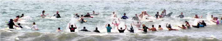  ?? ?? Boardrider­s headed to the backline for the traditiona­l memorial circle and splashing of the water to honour their fallen comrades