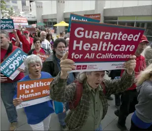  ?? RICH PEDRONCELL­I — THE ASSOCIATED PRESS ?? Supporters of single-payer health care march to the Capitol in Sacramento in 2017.