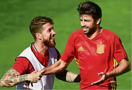  ??  ?? What’s the fuss about?: Spain’s Sergio Ramos (left) and Gerard Pique sharing a light moment at a training session. — AFP