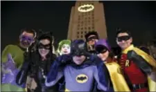  ?? PHOTO BY CHRIS PIZZELLO — INVISION — AP ?? Fans dressed as characters from “Batman” pose in front of a Bat-Signal projected onto City Hall following a tribute to “Batman” star Adam West on Thursday in Los Angeles.