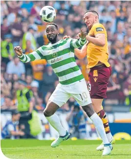 ??  ?? Moussa Dembele holds off Motherwell’s Tom Aldred