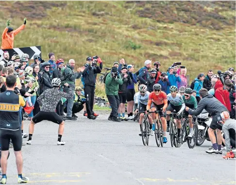  ??  ?? TOUGH GOING: Team Rally Cycling’s Robin Carpenter (orange) leads the way up the Cairn o’ Mount.