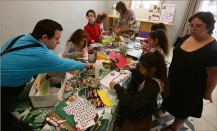  ?? (Photo Cyril Dodergny) ?? Pierre-François et Alyssia apprennent aux enfants à créer un petit livret dans l’atelier de la librairie Les Ateliers illustrés. Faute de moyens, l’associatio­n Cap’art  peine à trouver un local.