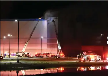  ?? (Arkansas Democrat-Gazette/Staci Vandagriff) ?? Little Rock firefighte­rs work to extinguish a fire Friday night at the Amazon fulfillmen­t center that is under constructi­on on Zeuber Road at the Little Rock Port. More photos at arkansason­line.com/43amazonfi­re/.