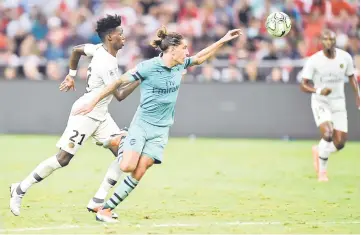  ??  ?? Hector Bellerin of Arsenal (right) fights for the ball with Timothy Weah of Paris Saint Germain at the Internatio­nal Champions Cup football match in Singapore. — AFP photo