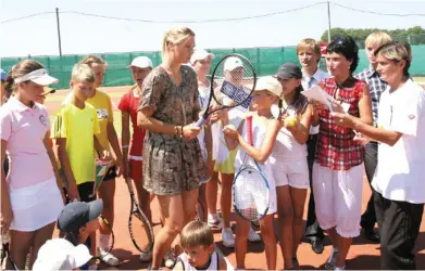  ??  ?? ◀ Мария Шарапова с юными теннисиста­ми из Гомеля. 2010 год