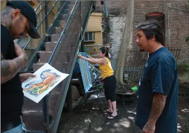  ?? BEA AHBECK/NEWS-SENTINEL ?? Hard Luck Tattoo Shop owners Trang and Bao Nguyen (middle, right), recover some artwork out of their tattoo studio after a three-alarm fire in a vacant building on Sacramento Street damaged their business in Downtown Lodi ON Saturday morning.