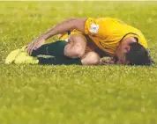  ??  ?? FLOORED: Socceroo Mark Milligan grabs at his ankle after being fouled.