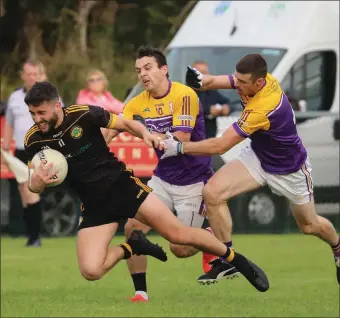  ?? ?? Ryan Lyons feels the pain of the pressure from Eamon Mchugh and Michael Jones.