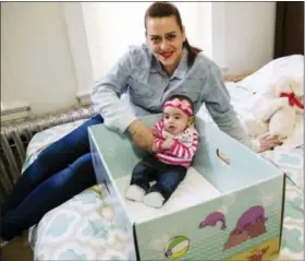  ?? (AP PHOTO/MATT ROURKE) ?? Dolores Peterson and her three-month-old daughter Ariabella pose for a photograph at their home in Camden, N.J., Monday, March 6, 2017. New Jersey became the first state to send newborn babies and their parents home with a box that doubles as a crib...