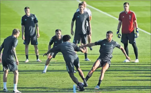  ??  ?? Cristiano y Cuadrado pugnan por un balón durante el entrenamie­nto de la Juventus, ayer.