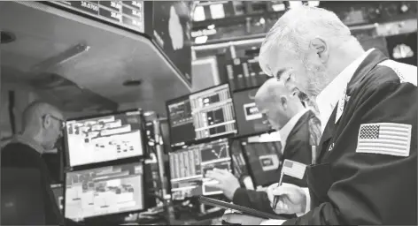  ?? NEW YORK STOCK EXCHANGE VIA AP ?? IN THIS PHOTO PROVIDED BY THE NEW YORK STOCK EXCHANGE, EDWARD MCCARTHY (right) works with fellow traders on the