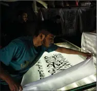  ?? (AP/Bernat Armangue) ?? Afghan workers hand-print Taliban flags Sunday at a small workshop in Kabul’s Jawid market.