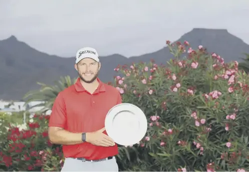  ??  ?? 0 Dean Burmester of South Africa poses with the trophy after winning the Tenerife Open at Golf Costa Adeje