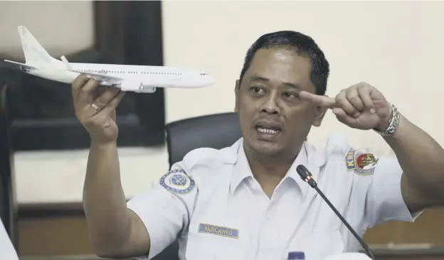  ??  ?? 0 National Transporta­tion Safety Committee investigat­or Nurcahyo Utomo holds a model of an airplane during a press conference on the findings