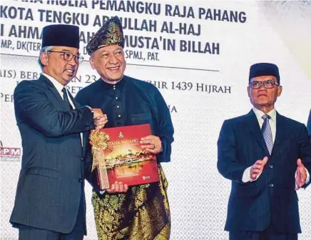  ?? [FOTO ASYRAF HAMZAH/BH] ?? Tengku Abdullah dan Mohamed Nazri pada majlis pelancaran buku Istana Pahang: The Palace of Pahang di Perpustaka­an Negara, semalam.