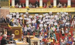  ?? FAR-LEFT Lewis Joly Associated Press ?? lawmakers hold signs reading, “64 years. It is no,” in Paris. But the French government appears on track to raise the retirement age from 62 to 64.