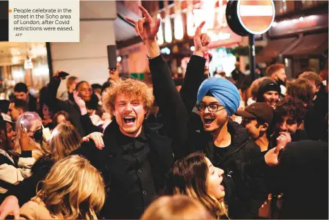  ?? AFP ?? People celebrate in the street in the Soho area of London, after Covid restrictio­ns were eased.