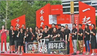  ?? HOU YU / CHINA NEWS SERVICE ?? Top: JD employees pose for a photo to commemorat­e the 17th anniversar­y of the 618 Midyear Shopping Festival outside the company’s headquarte­rs in Beijing on June 17.