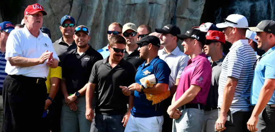  ??  ?? PLAYING THE GREENS: US President Donald Trump speaks to members of the United States Coast Guard during an invitation to play golf at Trump Internatio­nal Golf Club in Florida, last Friday. Photo: Nicholas Kamm/Getty