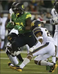  ?? CHRIS PIETSCH ?? Oregon’s Royce Freeman (center) rushes against California’s Elijah Hicks (left) and Quentin Tartabull (right) during the first quarter of an NCAA college football game, Saturday, Eugene, Ore. AP PHOTO/