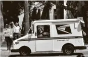  ?? Jeff Gritchen / Orange County Register ?? A mail carrier drives past protesters Tuesday during a rally against changes to the Postal Service in Newport Beach, Calif.