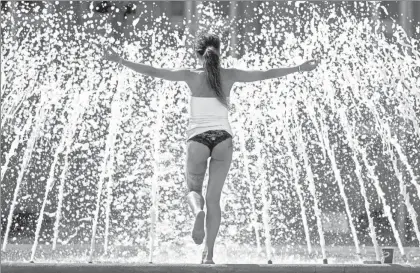  ?? Foto Ap ?? Una mujer hace yoga en una fuente en el centro de Stuttgart, Alemania