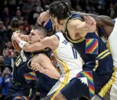  ?? ?? Jokic is fouled by the Warriors’ Klay Thompson. Aaron Ontiveroz, The Denver Post