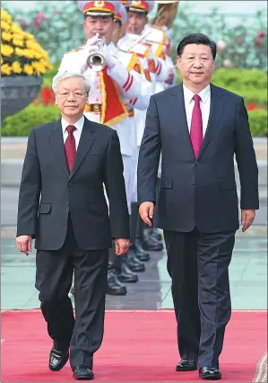  ?? FENG YONGBIN / CHINA DAILY ?? Xi Jinping, general secretary of the Communist Party of China Central Committee, walks with Nguyen Phu Trong, Xi’s counterpar­t in Vietnam’s Communist Party, during a welcoming ceremony in Hanoi on Sunday.